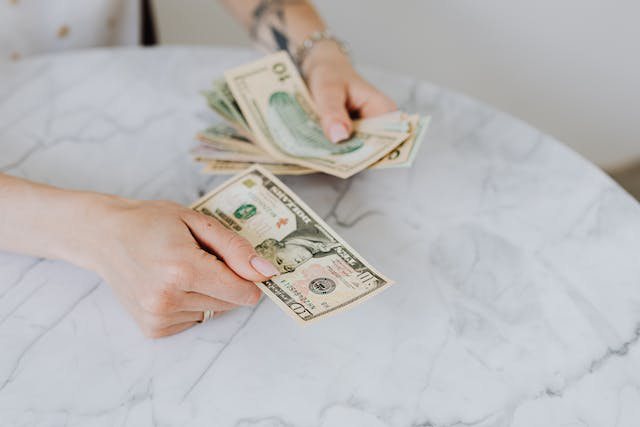 An investor meticulously counting dollar bills