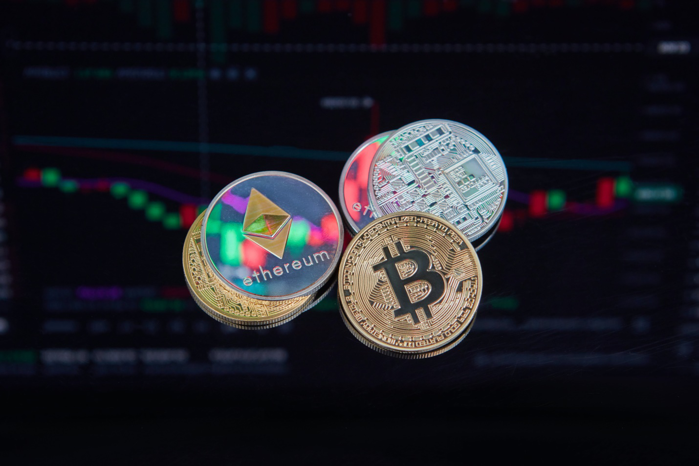 different coins such as bitcoin with backdrop of a trading data char