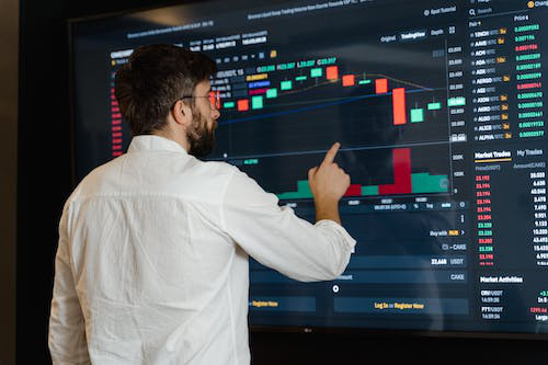 man monitoring the crypto market on a big screen