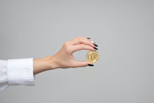 woman’s hand close up holding a Bitcoin