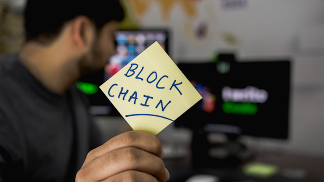 An individual holding a blockchain sticker