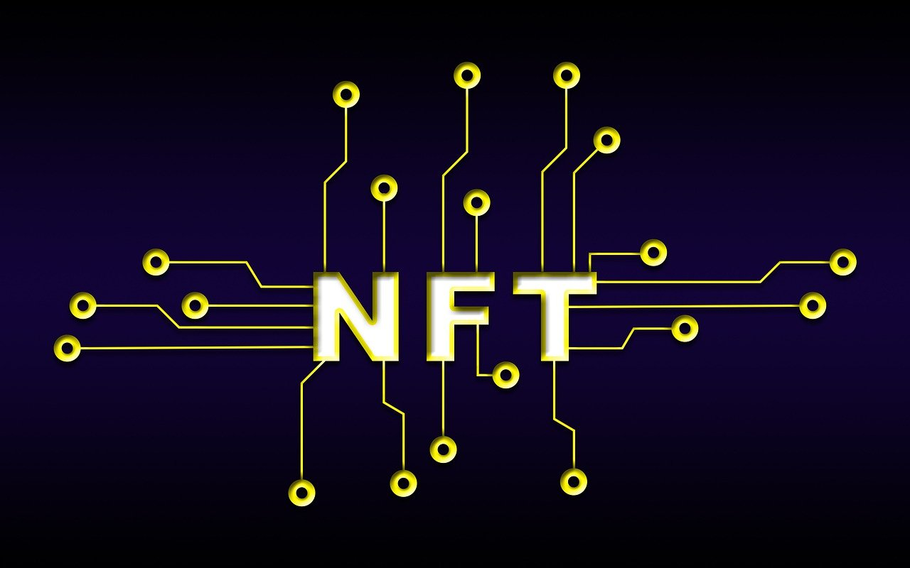 The word "NFT" written in yellow capital letters in the center of a black circuit board.