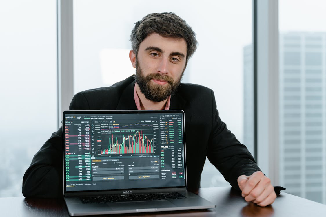 digital asset management consultant using market trends on a laptop for crypto asset allocation