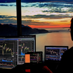 A person analyzing multiple trading charts on screens.