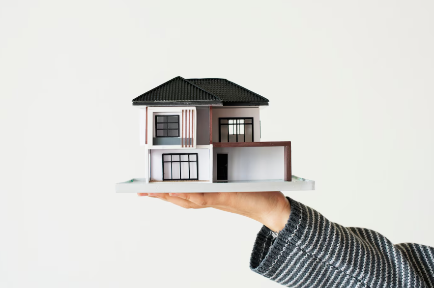 a hand presenting model house