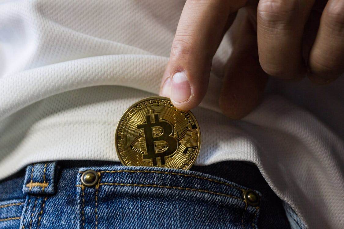 Man putting Bitcoin in his jean’s pocket