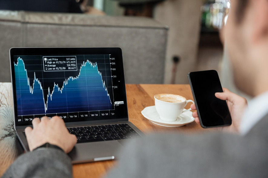 a businessman sitting by the table and analyzing indicators on a laptop