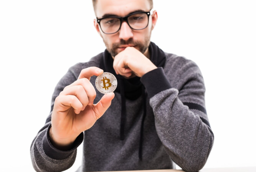 a man thinking with Bitcoin in his hand