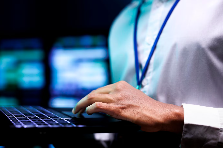 a computer scientist using laptop to analyze server cabinets