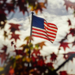 An American flag waving proudly against a cloudy sky.