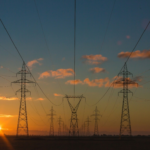 A row of power lines against a sunset sky.