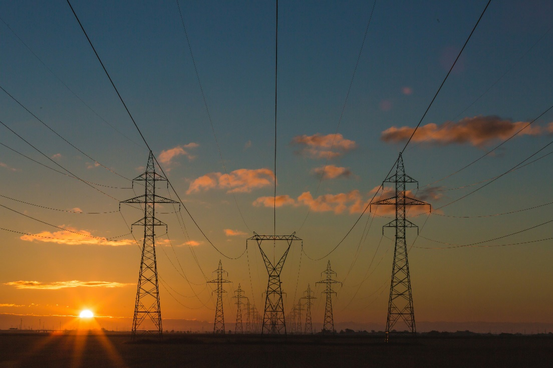 A row of power lines against a sunset sky.