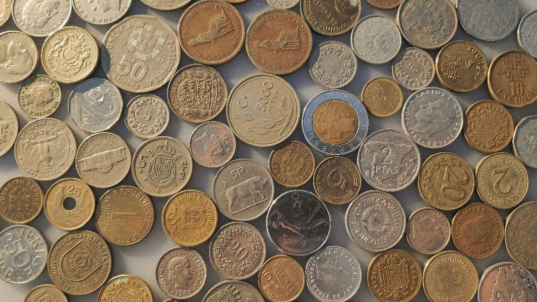 A collection of coins from different countries, representing the diversity of global currencies.