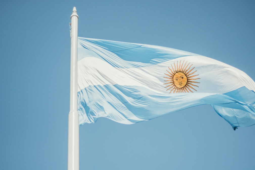 The flag of Argentina waving against a blue sky.