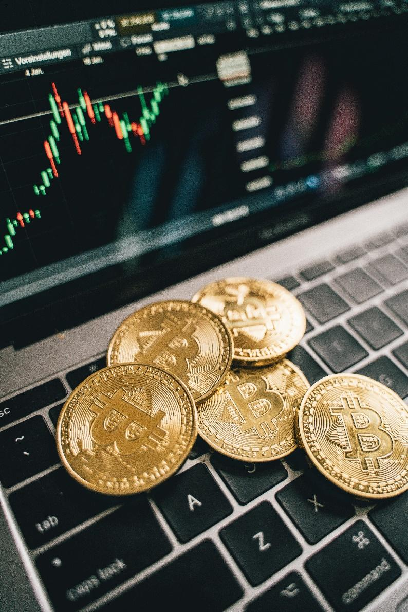 Gold coins placed on a laptop keyboard.