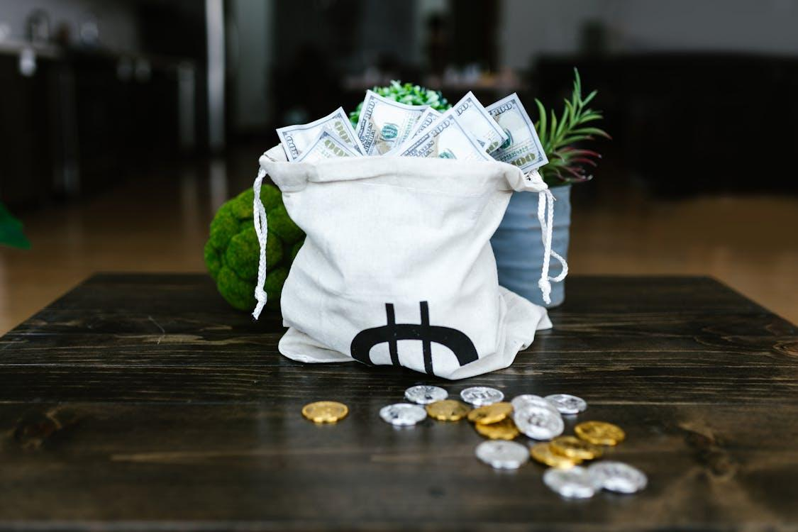 kenson Investments | From Political Heat to Crypto Beat: Eric Trump’s Bitcoin Revelation money on a tote bags and coins on the table