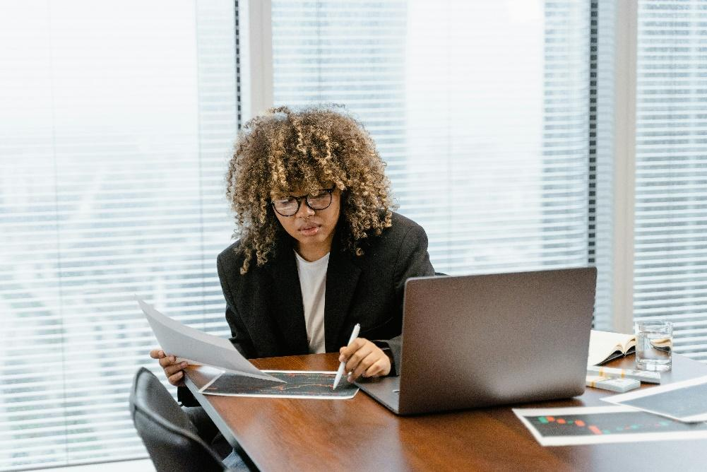 Business professional using a laptop with marketing charts, reflecting digital asset integration in business operations.