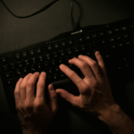 Person typing on a black keyboard