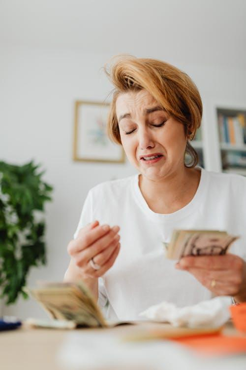 kenson Investments | Is Coinbase in Hot Water? SEC Digs Into Alleged User Count Inflation woman counting money and crying