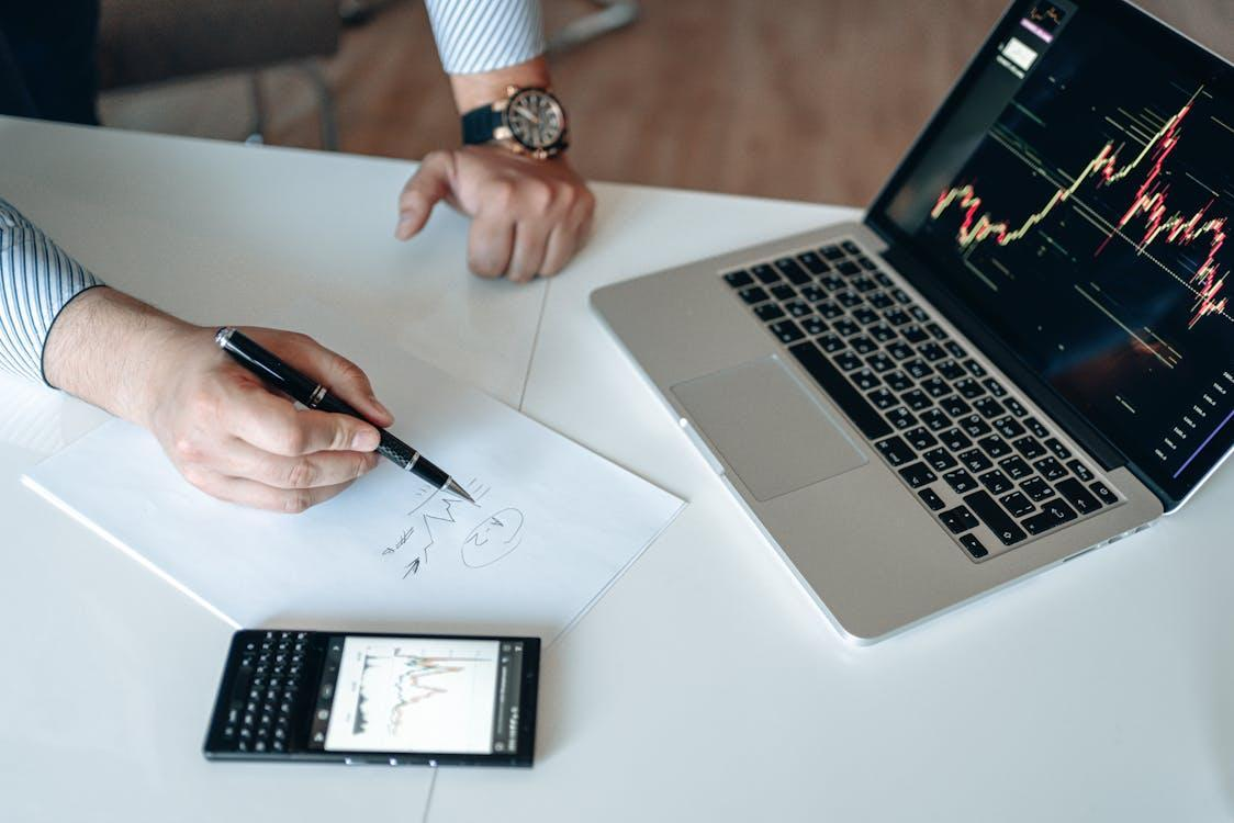 kenson Investments | June’s Crypto Shake-Up: Are Altcoins Ready to Steal Bitcoin’s Thunder? analyzing graphs on a paper