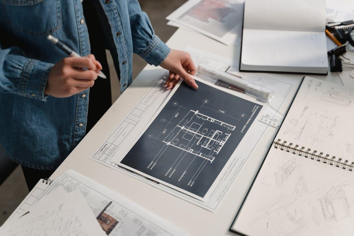person in blue denim jacket holding white printer paper