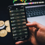 person holding a smartphone with trading graphs