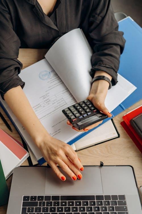 kenson Investments | Tokenized Asset Structures: Managing Security Considerations in 2025 person holding black calculator while using laptop