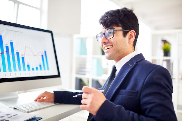 kenson Investments | The Global Push for Standardized Crypto Accounting and Reporting man in formal dressing looking at a computer in the office