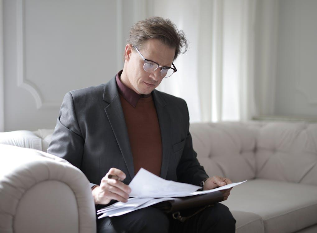 kenson Investments | Smart Contract Audit Evolution – The Role of AI and Human Oversight classy executive male reading papers on couch