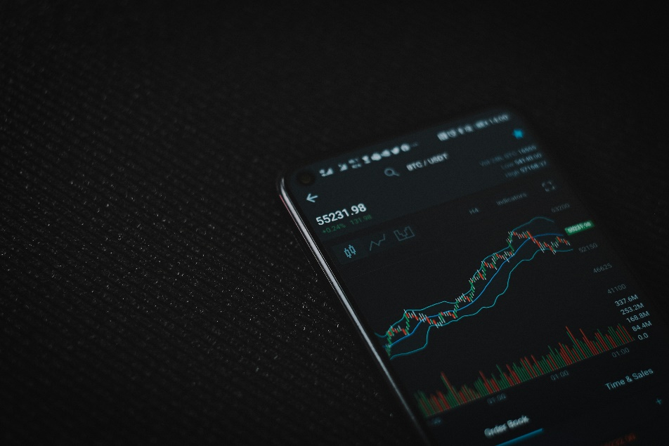 kenson Investments | Crypto Leaders Express Optimism Amid Regulatory Advances Black smartphone on dark fabric surface.