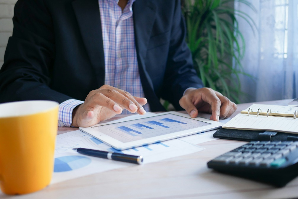 kenson Investments | Grant Thornton's 2025 Crypto Policy Outlook: Shaping the Future of Stablecoins Professional holding a tablet reviewing digital asset regulations and stablecoin policies.
