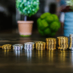 A collection of silver and gold Bitcoin tokens displayed on a wooden table.