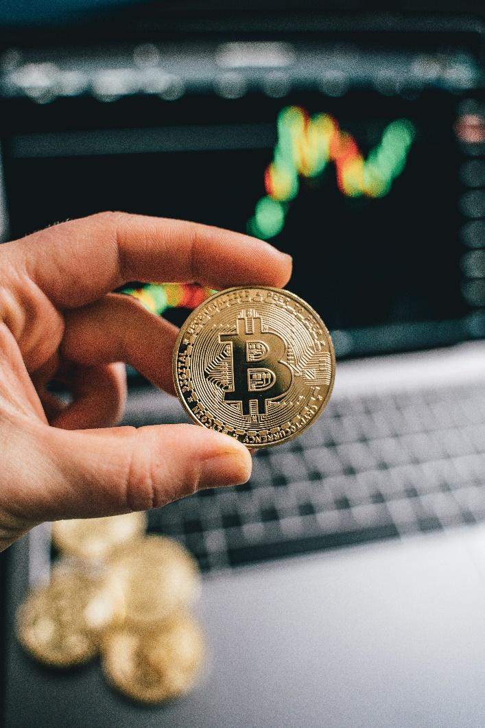 A person holding a gold Bitcoin