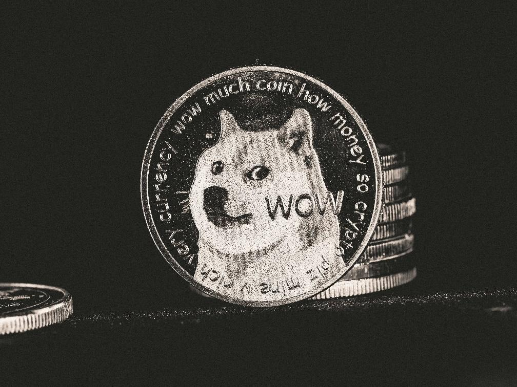kenson Investments | The Memecoin Mirage: Market Hype, TRUMP, PEPE, and the Risk Spectrum A physical Dogecoin, representing the broader memecoin market.