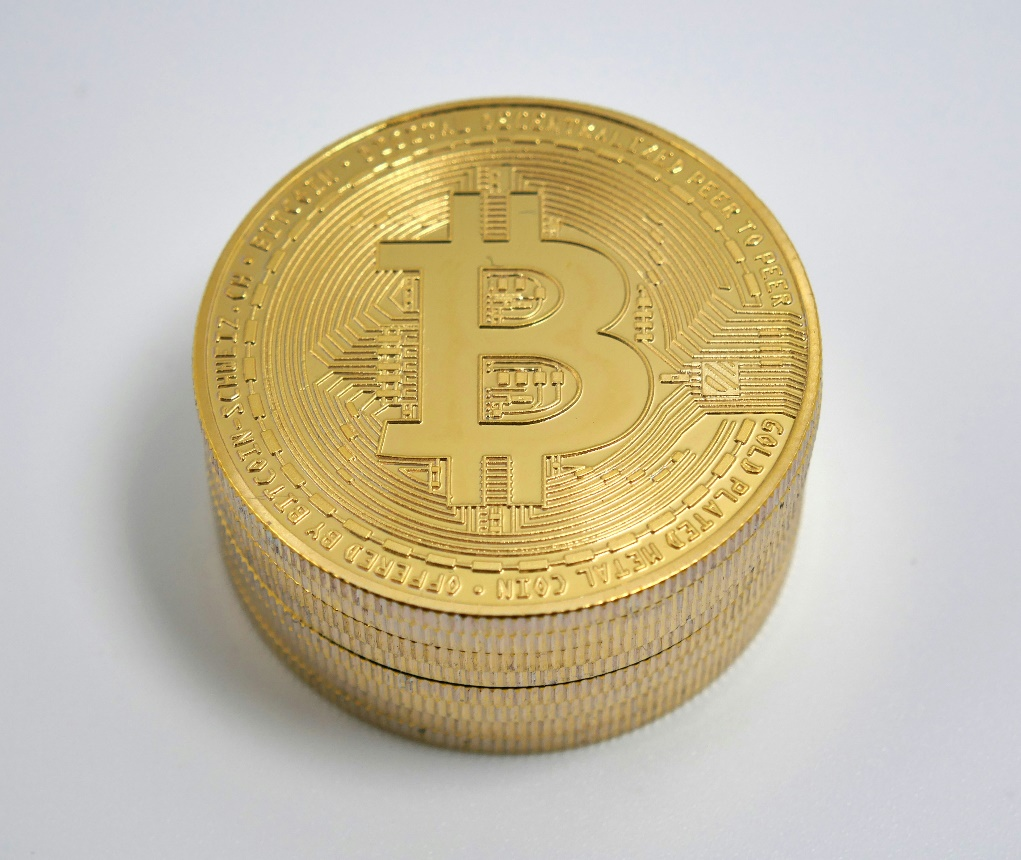 Gold Bitcoin coin resting on a table.
