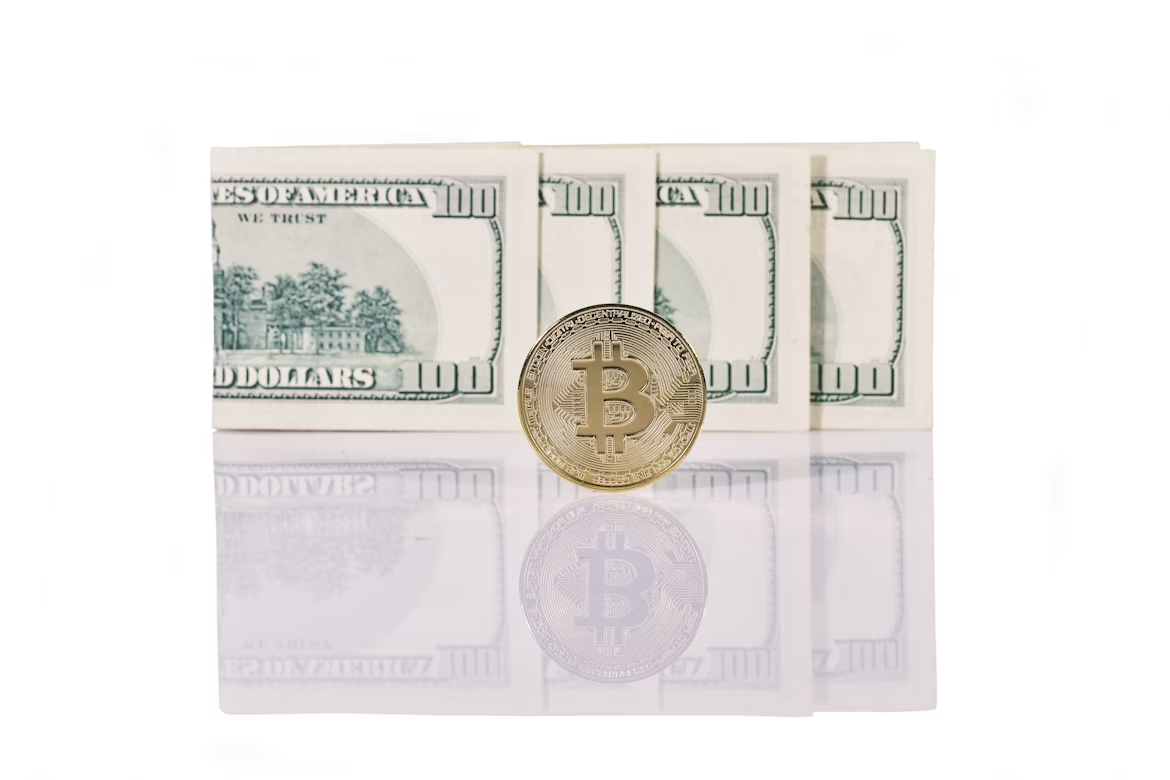 Bitcoin coin sitting on top of a pile of US dollar bills, symbolizing crypto wealth and cash-out opportunities