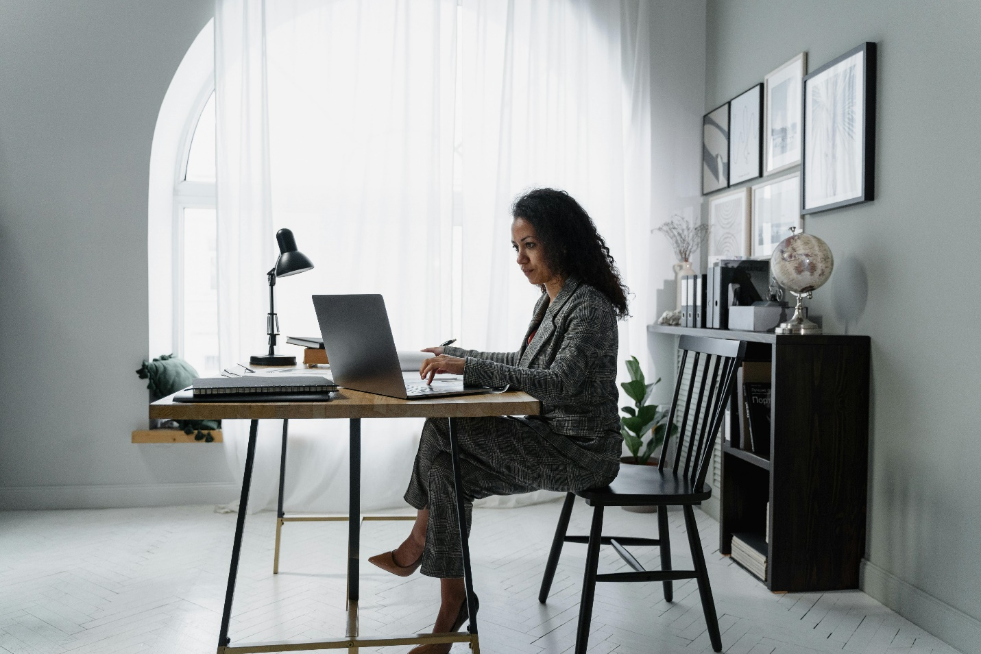 Professional woman working remotely on a laptop, representing global workforce participation and digital payroll solutions.