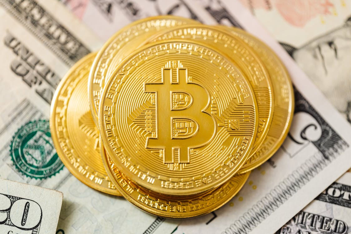 kenson Investments | Why Bitcoin Could Be a Big Winner if More Inflation Happens Physical Bitcoin tokens placed on U.S. dollar bills