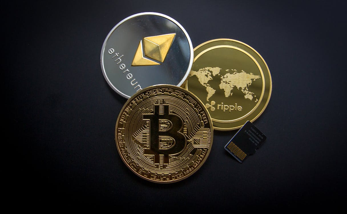 Bitcoin, Ethereum, and Ripple tokens representing regulated digital asset activity.