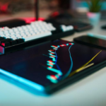 Tablet displaying market charts beside a keyboard illustrating post-trade surveillance and exposure monitoring in tokenized markets