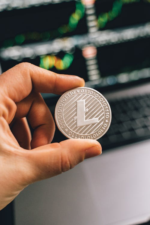 Person holding a silver coin, representing a lithium-related or tokenized digital asset.