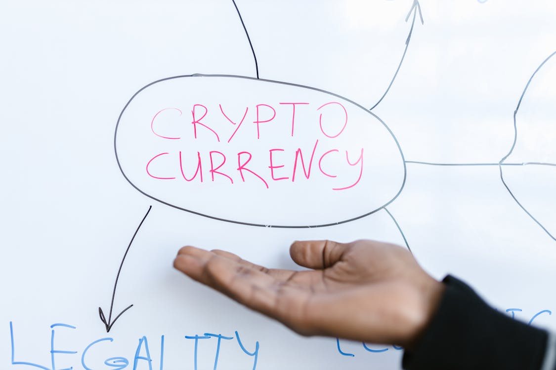 Person pointing at a whiteboard with “cryptocurrency” circled, illustrating digital asset strategy and planning.