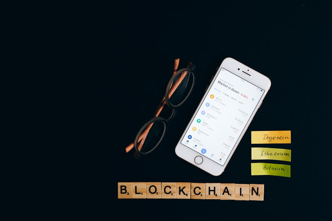 Blockchain spelled with Scrabble blocks next to a smartphone.