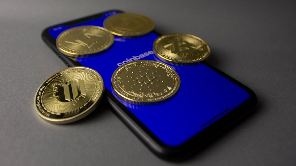 Bitcoin lying on top of a smartphone.