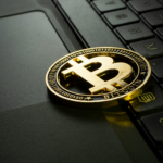 physical bitcoin coin placed on laptop.
