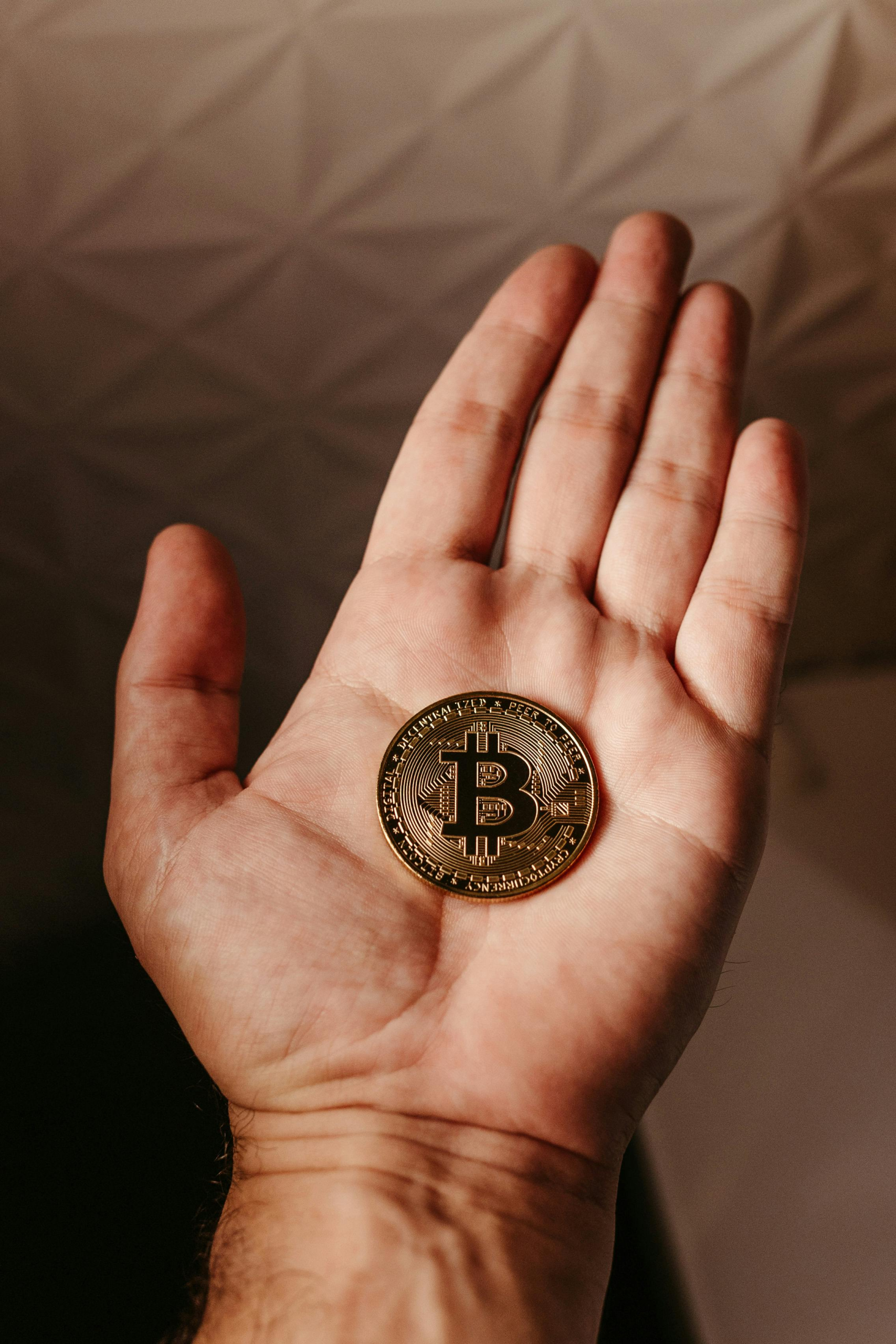 hand holding a bitcoin coin.
