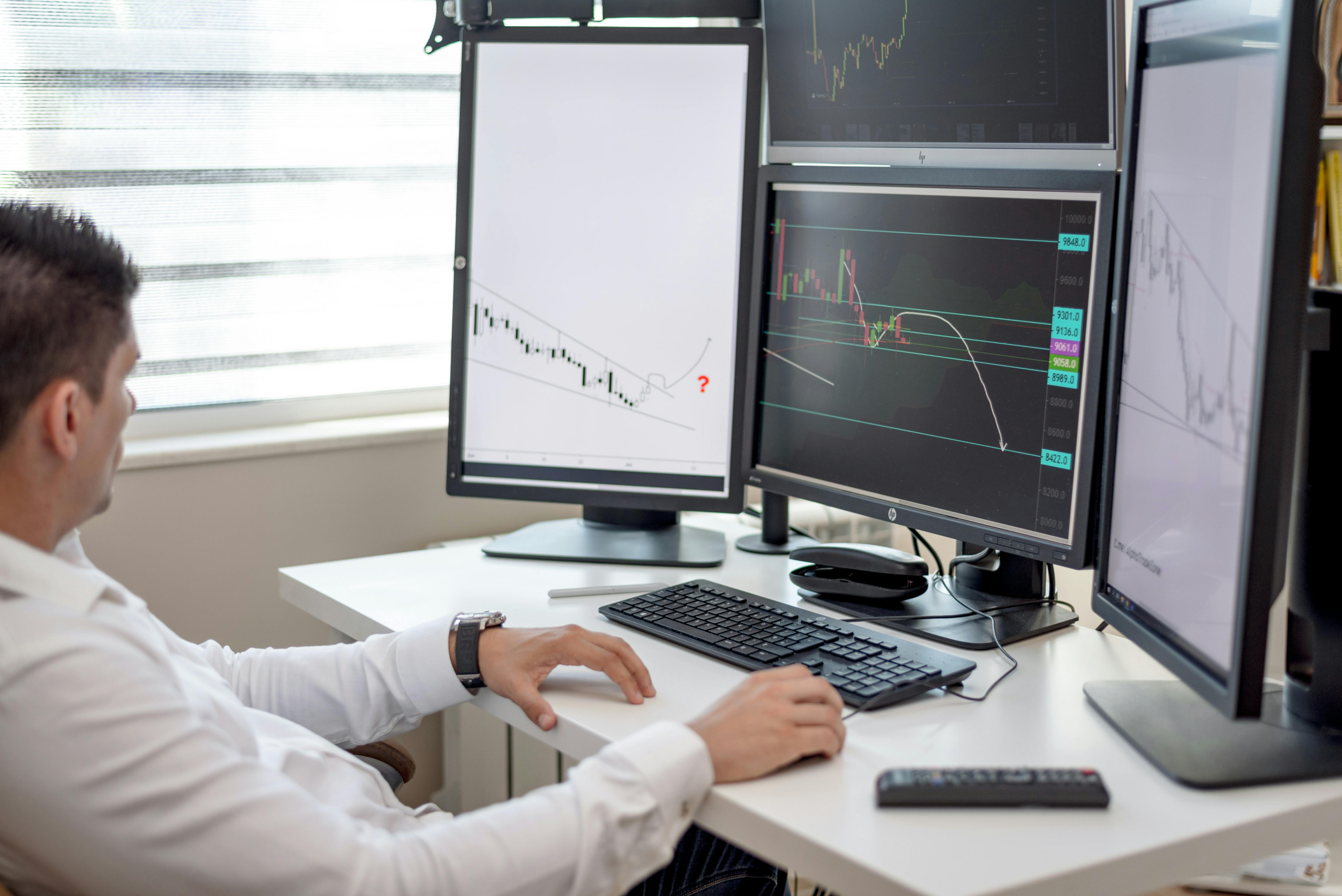 trader analyzing multiple charts and price movements across screens to evaluate digital asset market trends