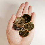 hand holding multiple cryptocurrency coins