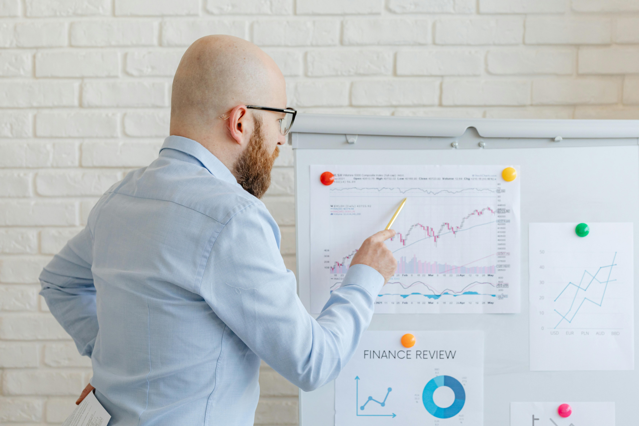 analyst reviewing financial charts on board to assess trends and performance in digital and traditional markets