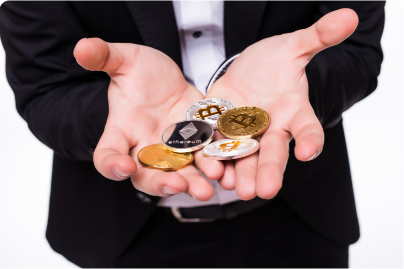 Crypto investor holding various digital currency coins in hand representing blockchain-based assets